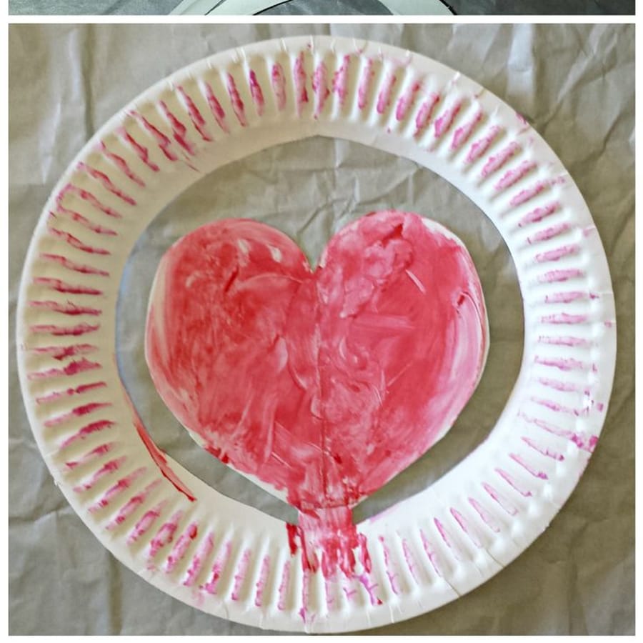 Preschool children happily showcasing their Valentine\'s Day paper plate hats