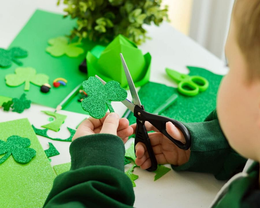 Preschool kids proudly displaying their St. Patrick\'s Day crafts