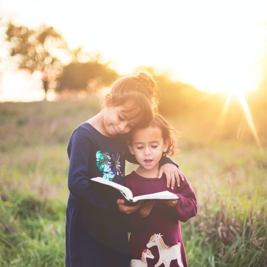 Happy preschool children wearing graduation caps and gowns